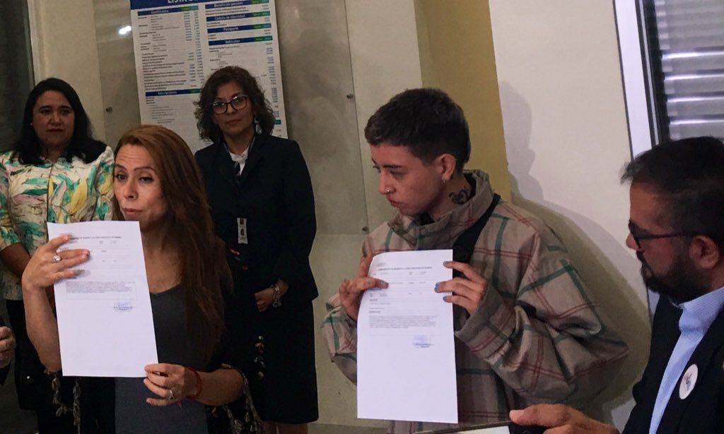 De izquierda a derecha Noah López y Valeria Pinto muestran la solicitud de hora para el cambio de nombre y sexo registral